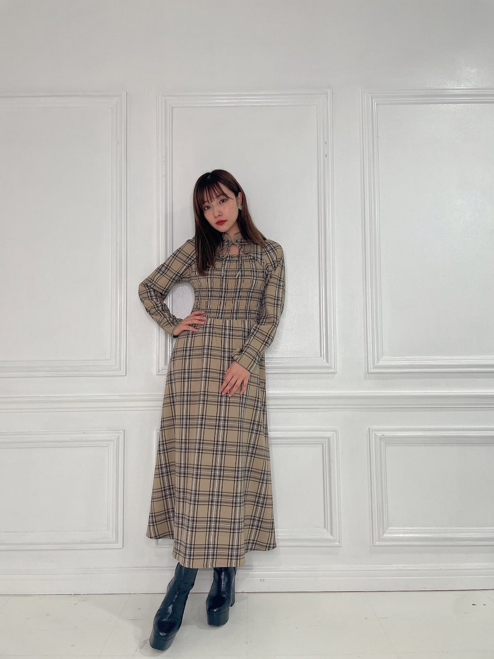 ベージュ系のワンピース、ブラック系のブーツを着用したレディースの春コーディネートの2枚目の写真