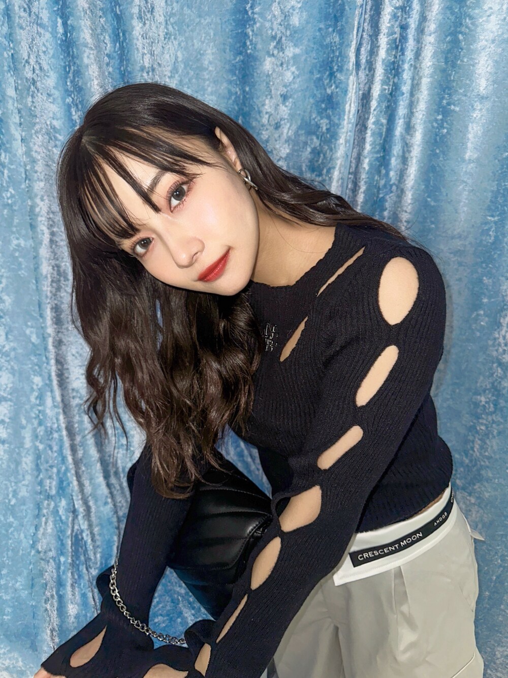 ブラック系のニット/セーター、グレー系のカーゴパンツ、ブラック系のショルダーバッグを着用したレディースの春コーディネートの3枚目の写真