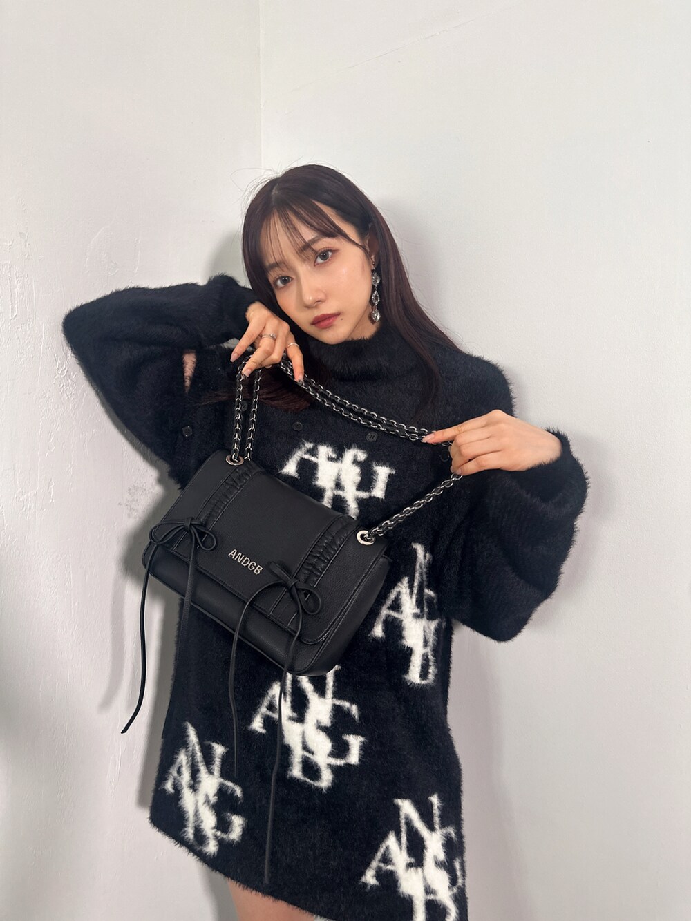 ブラック系のワンピース、ブルー系のショルダーバッグを着用したレディースの冬コーディネートの2枚目の写真