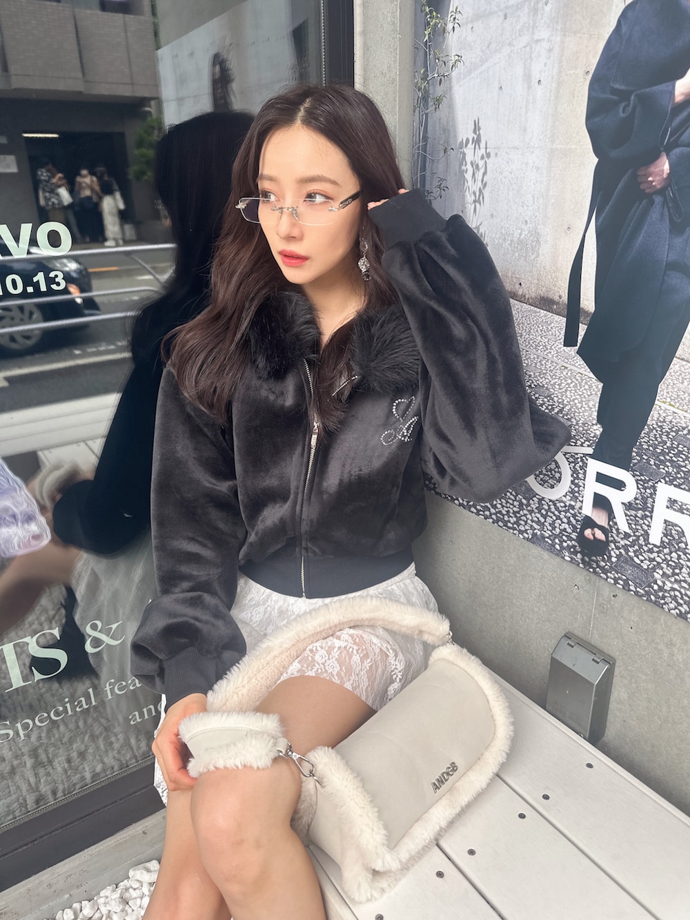 ブラック系のパーカー、ホワイト系のショルダーバッグを着用したレディースの冬コーディネートの2枚目の写真