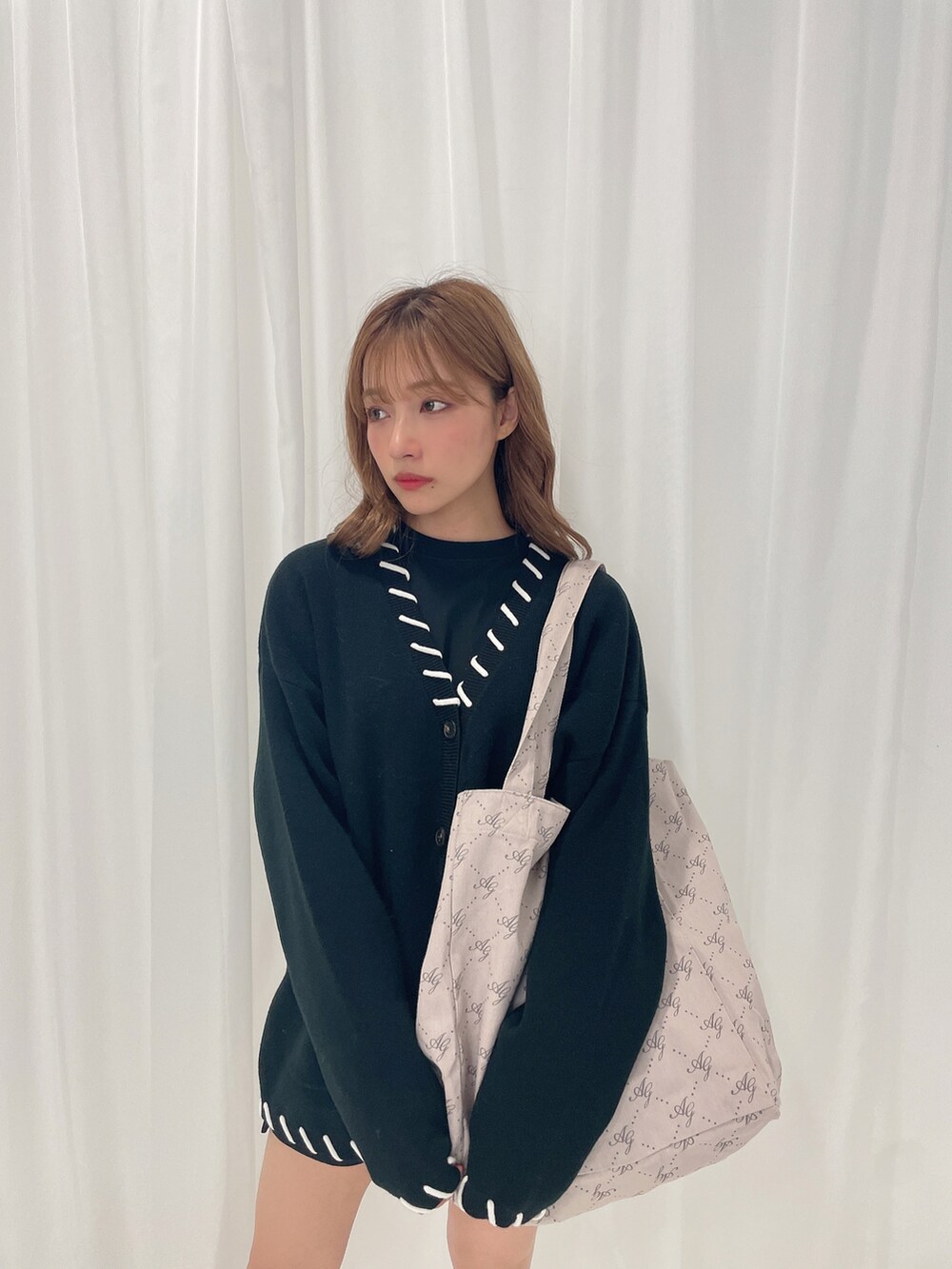 ブラック系のカーディガン/ボレロ、グレー系のトートバッグを着用したレディースの秋コーディネートの2枚目の写真