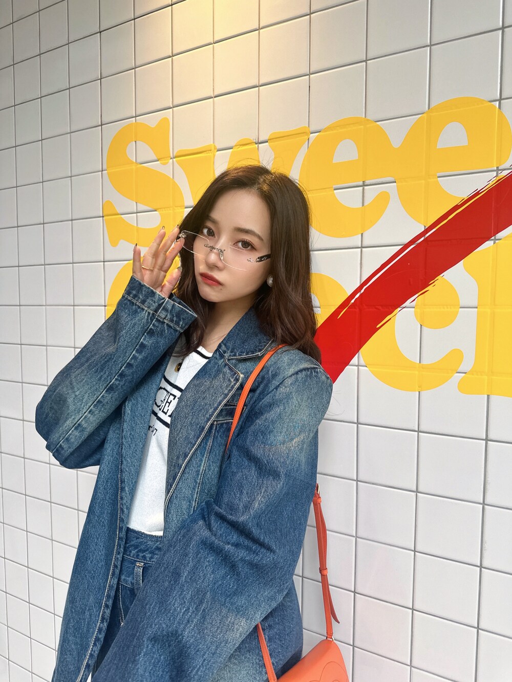 ブルー系のニット/セーター、ブルー系のデニムジャケット、ブルー系のスカートを着用したレディースの夏コーディネートの5枚目の写真