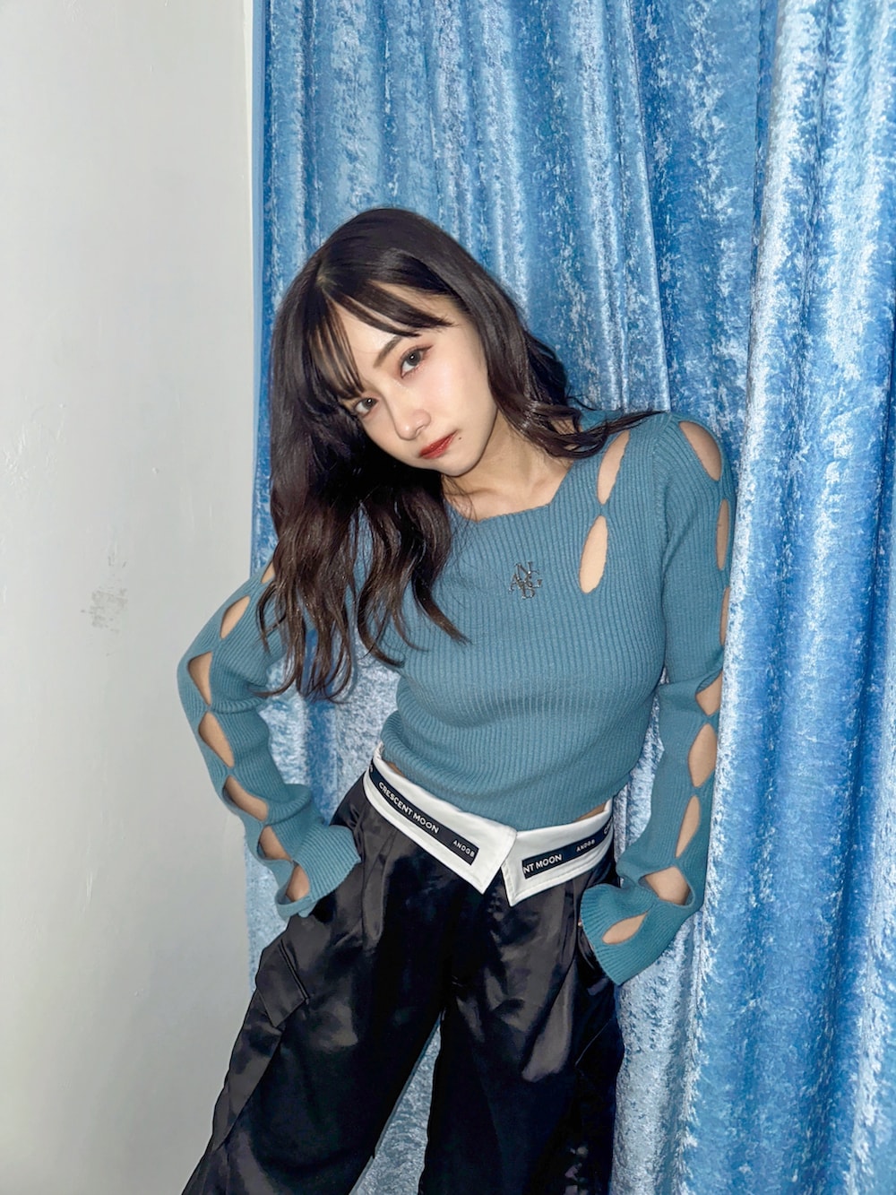 ブルー系のニット/セーター、ブラック系のカーゴパンツを着用したレディースの春コーディネートの3枚目の写真