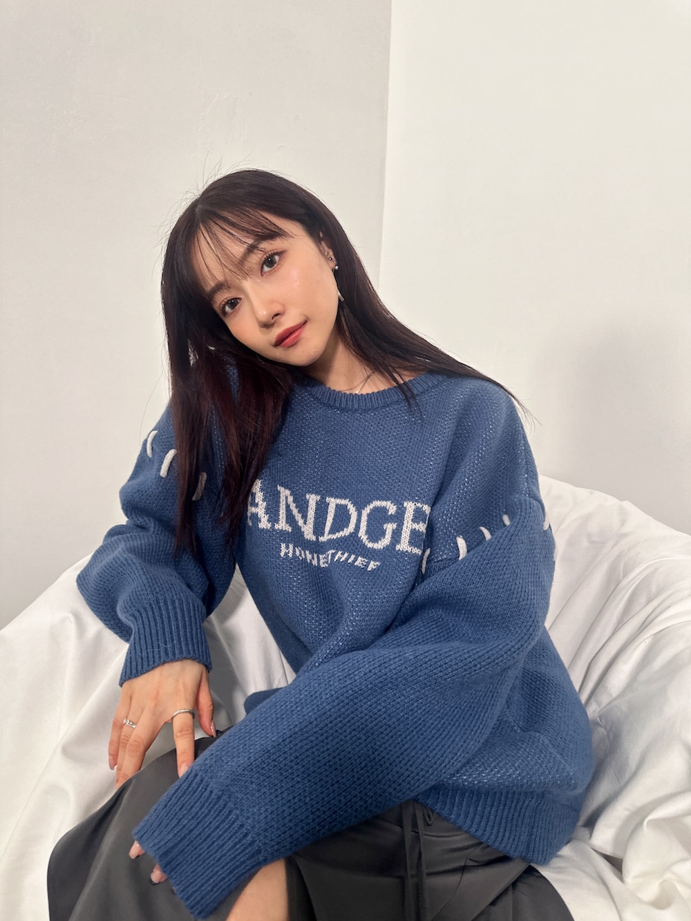 ブルー系のニット/セーター、グレー系のスカートを着用したレディースの冬コーディネートの3枚目の写真