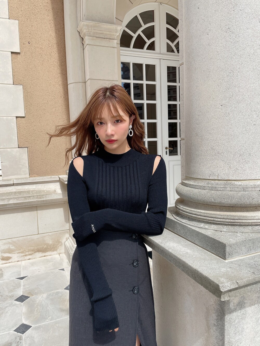 ブラック系のスカート、ブラック系のニット/セーター、ブラック系のブーツを着用したレディースの秋コーディネートの3枚目の写真