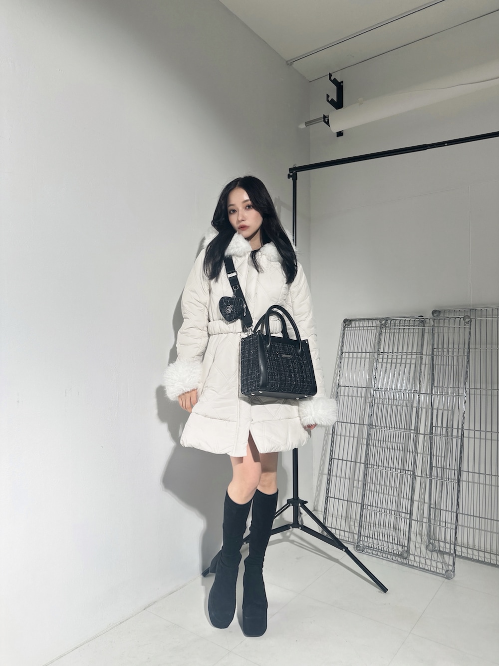ホワイト系のダウンジャケット/コート、グレー系のショルダーバッグを着用したレディースの冬コーディネートの2枚目の写真