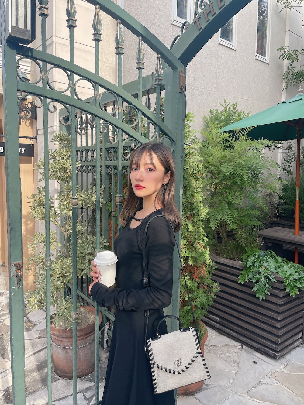 ベージュ系のショルダーバッグ、ブラック系のワンピースを着用したレディースの春コーディネートの3枚目の写真