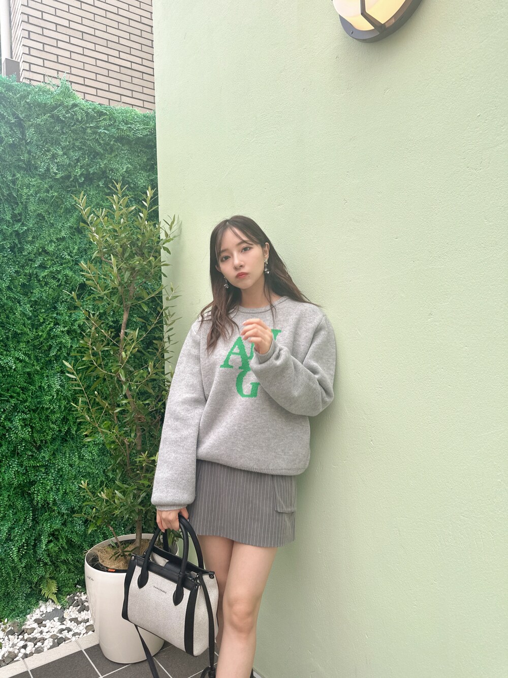 ブルー系のニット/セーター、ブラック系のショルダーバッグを着用したレディースの冬コーディネートの2枚目の写真