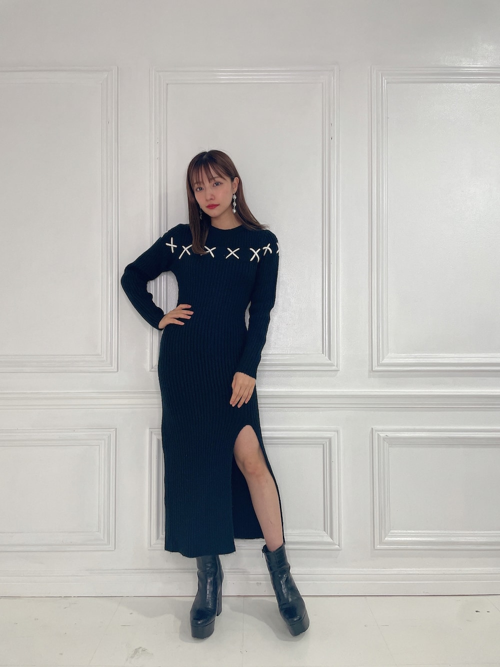 ブラック系のワンピース、ブラック系のブーツを着用したレディースの春コーディネートの2枚目の写真