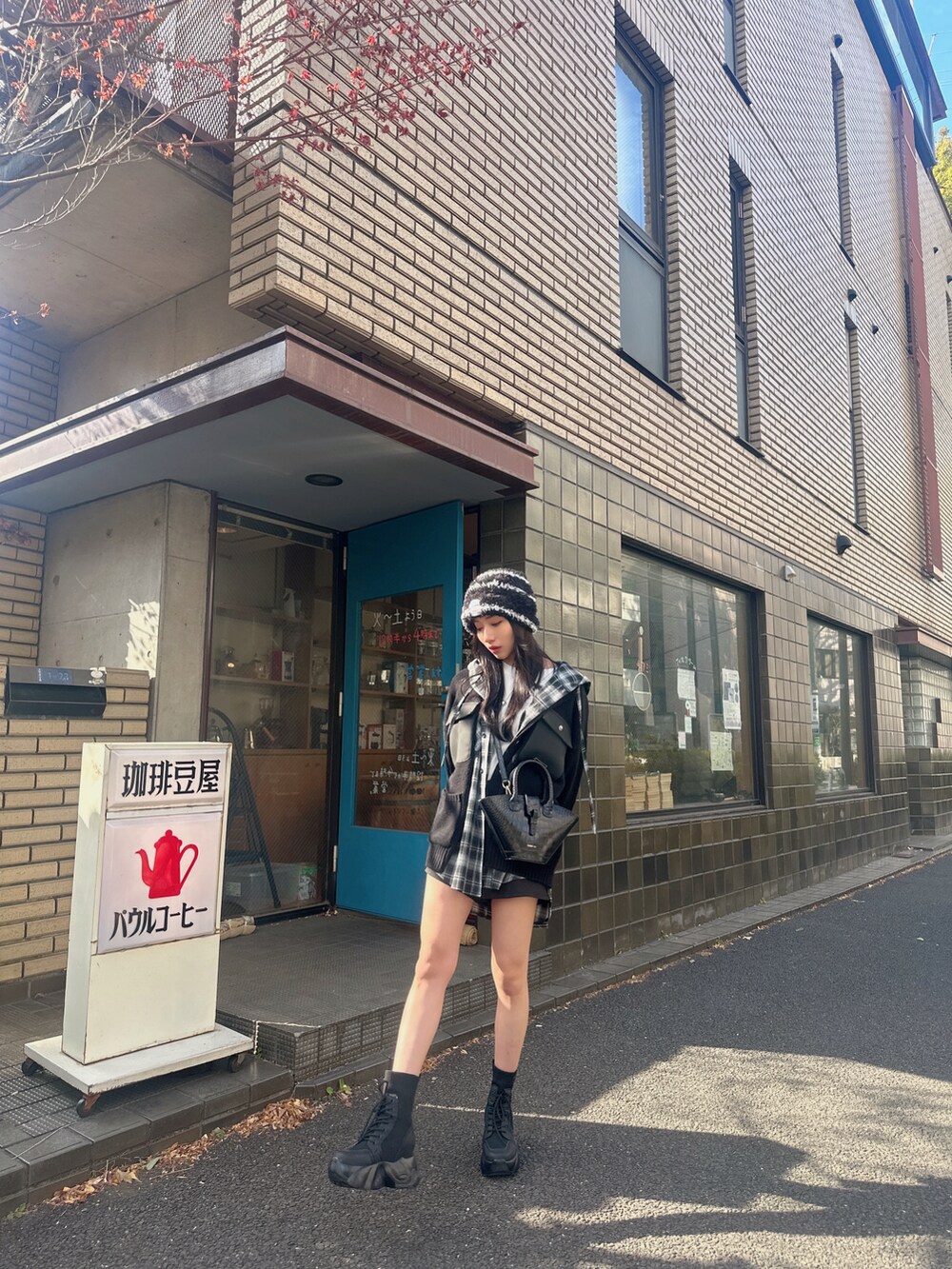 ブラック系のニット/セーター、ブラック系のシャツ/ブラウスを着用したレディースの春コーディネートの2枚目の写真