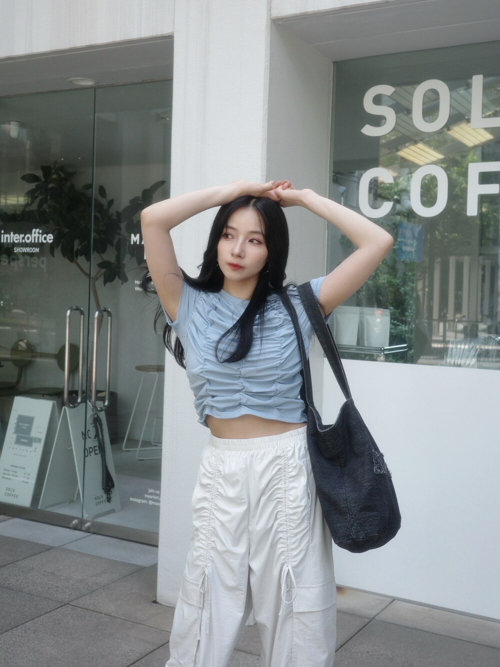 ブラック系のトートバッグ、ベージュ系のカーゴパンツ、ブルー系のTシャツ/カットソーを着用したレディースの秋コーディネートの4枚目の写真