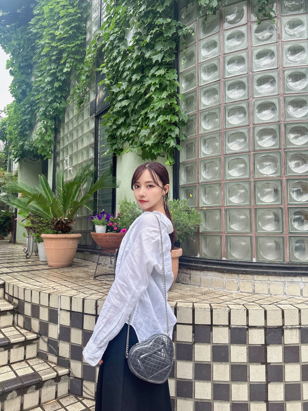 ブラック系のショルダーバッグ、ブラック系のワンピースを着用したレディースの夏コーディネートの3枚目の写真