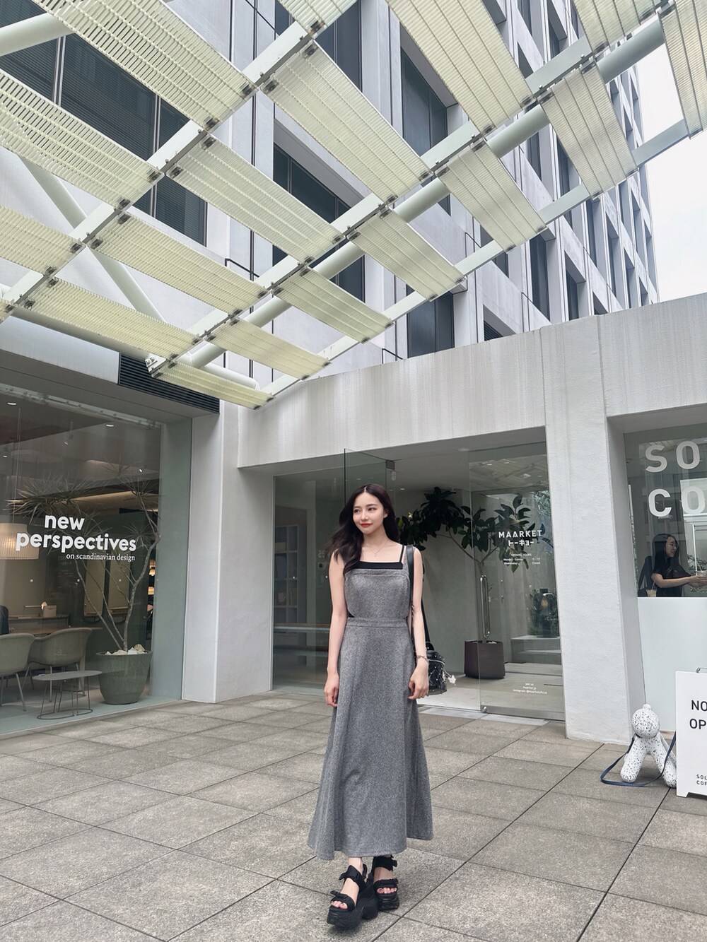 ホワイト系のショルダーバッグ、ブラック系のワンピースを着用したレディースの秋コーディネートの2枚目の写真