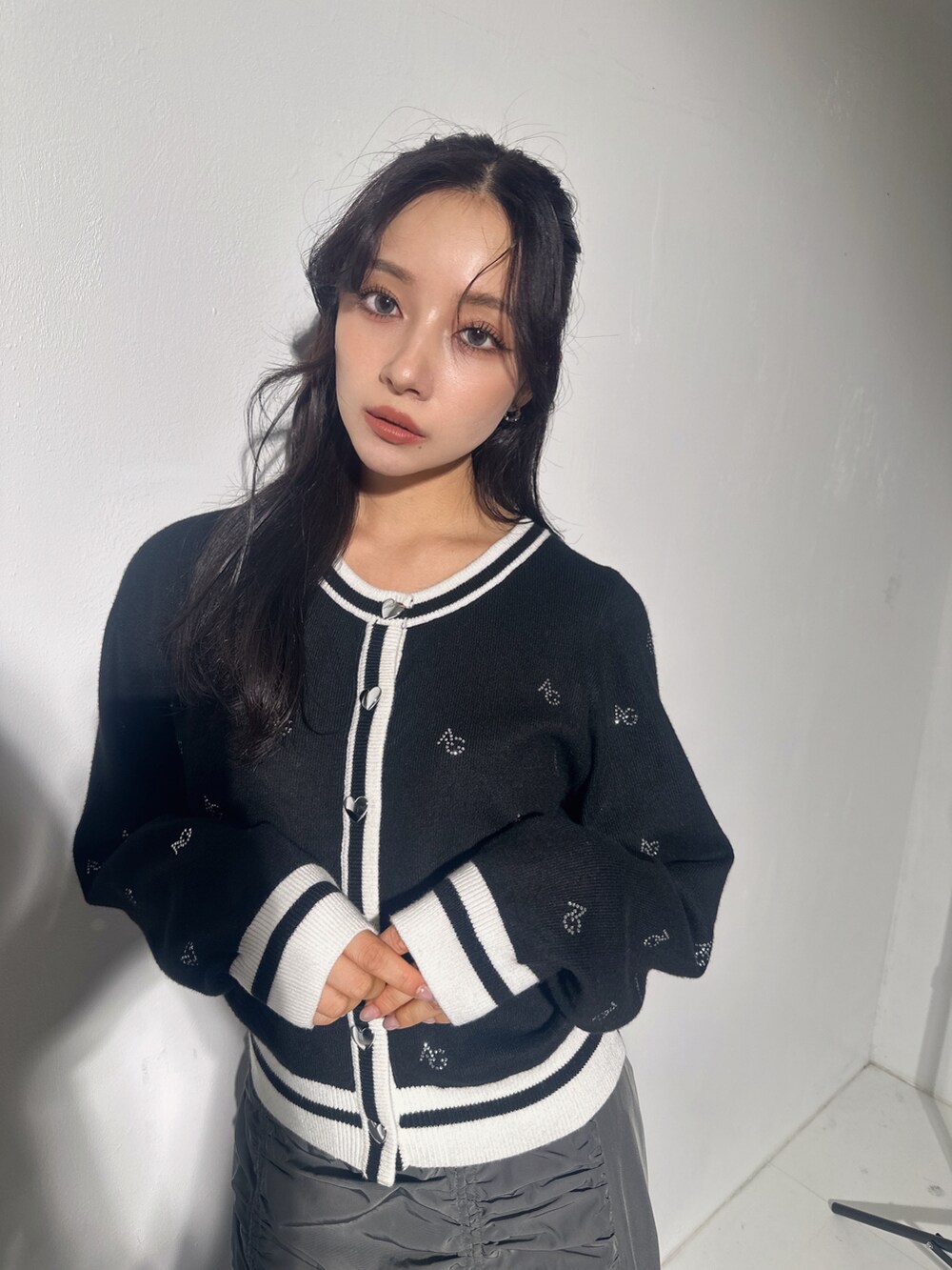 ブラック系のアンサンブル、グレー系のスカートを着用したレディースの冬コーディネートの3枚目の写真