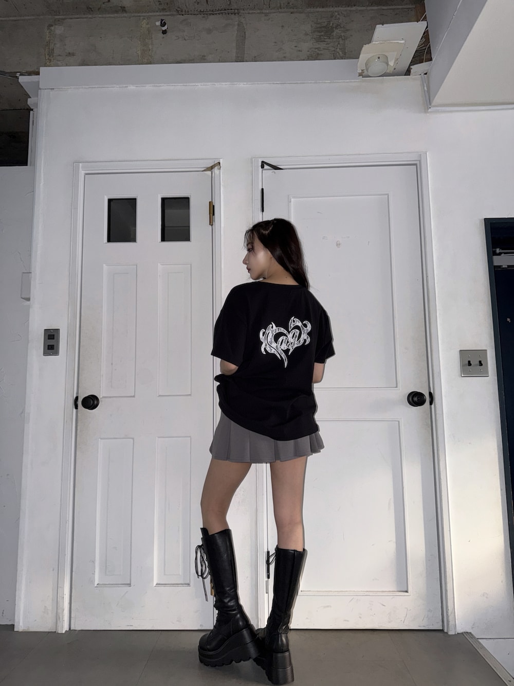 ブラック系のTシャツ/カットソー、グレー系のスカートを着用したレディースの春コーディネートの3枚目の写真