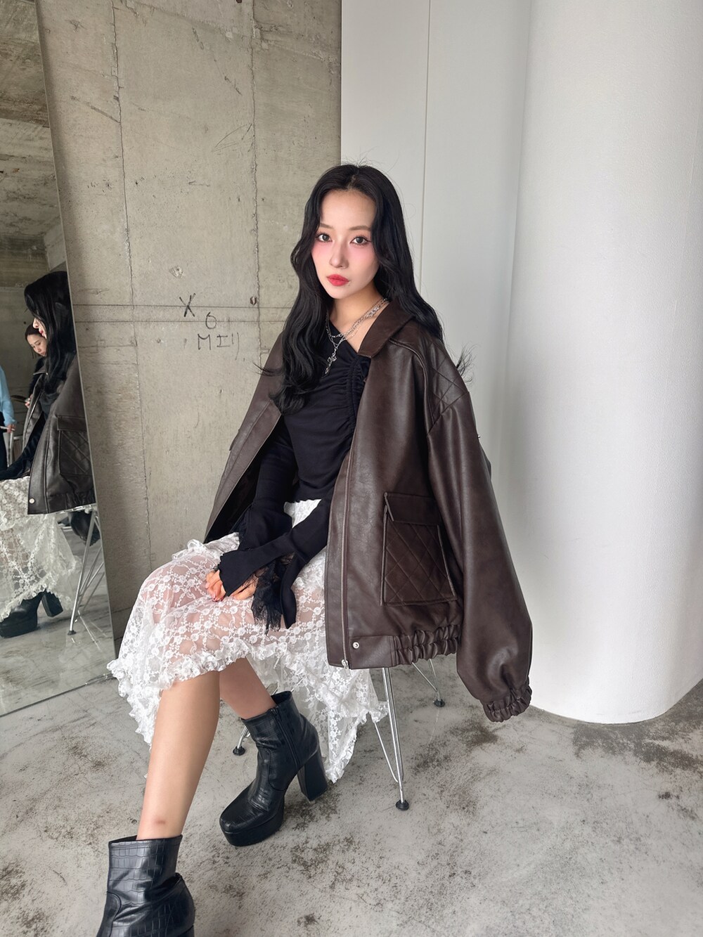 ブラウン系のブルゾン、ブラック系のTシャツ/カットソー、ホワイト系のスカートを着用したレディースの春コーディネートの4枚目の写真