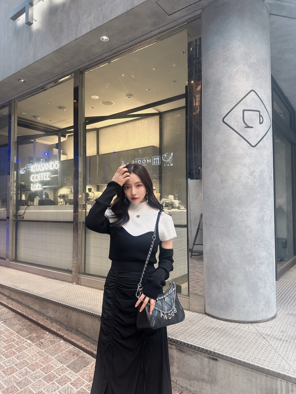 ホワイト系のニット/セーター、ブラック系のスカート、ブラック系のショルダーバッグを着用したレディースの冬コーディネートの4枚目の写真