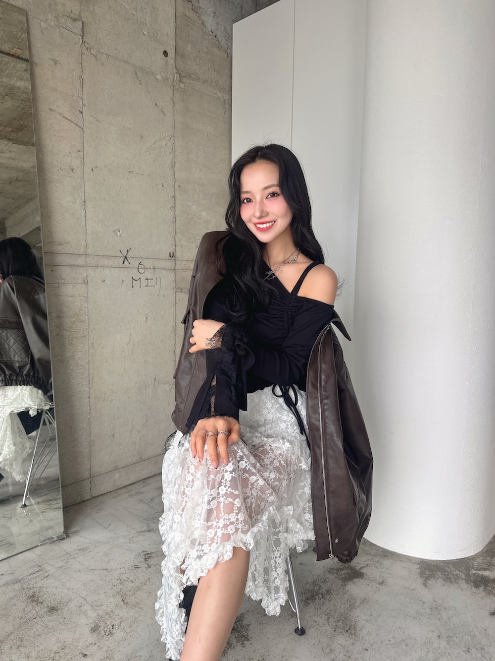 ブラウン系のブルゾン、ブラック系のTシャツ/カットソー、ホワイト系のスカートを着用したレディースの春コーディネートの3枚目の写真