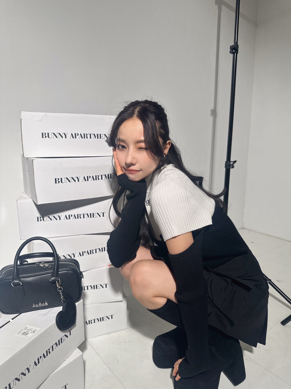 ホワイト系のニット/セーター、ブラック系のスカート、ブラック系のショルダーバッグを着用したレディースの冬コーディネートの5枚目の写真