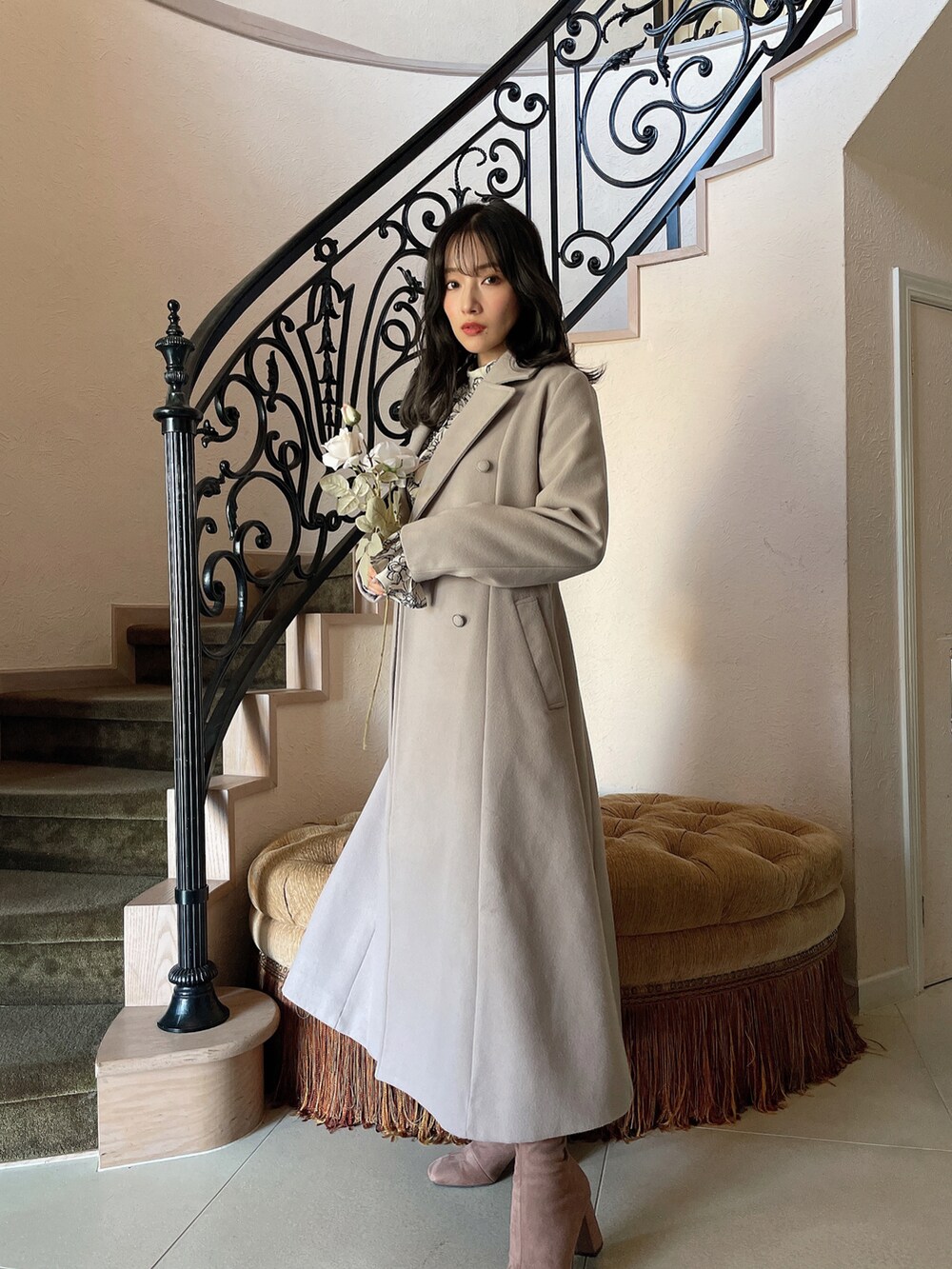 グレー系のチェスターコート、ベージュ系のワンピースを着用したレディースの春コーディネートの2枚目の写真