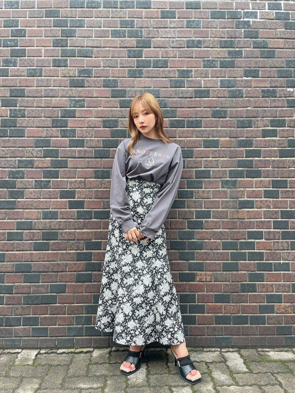 ブラック系のTシャツ/カットソー、ブラック系のスカート、ブラック系のサンダルを着用したレディースの秋コーディネートの5枚目の写真