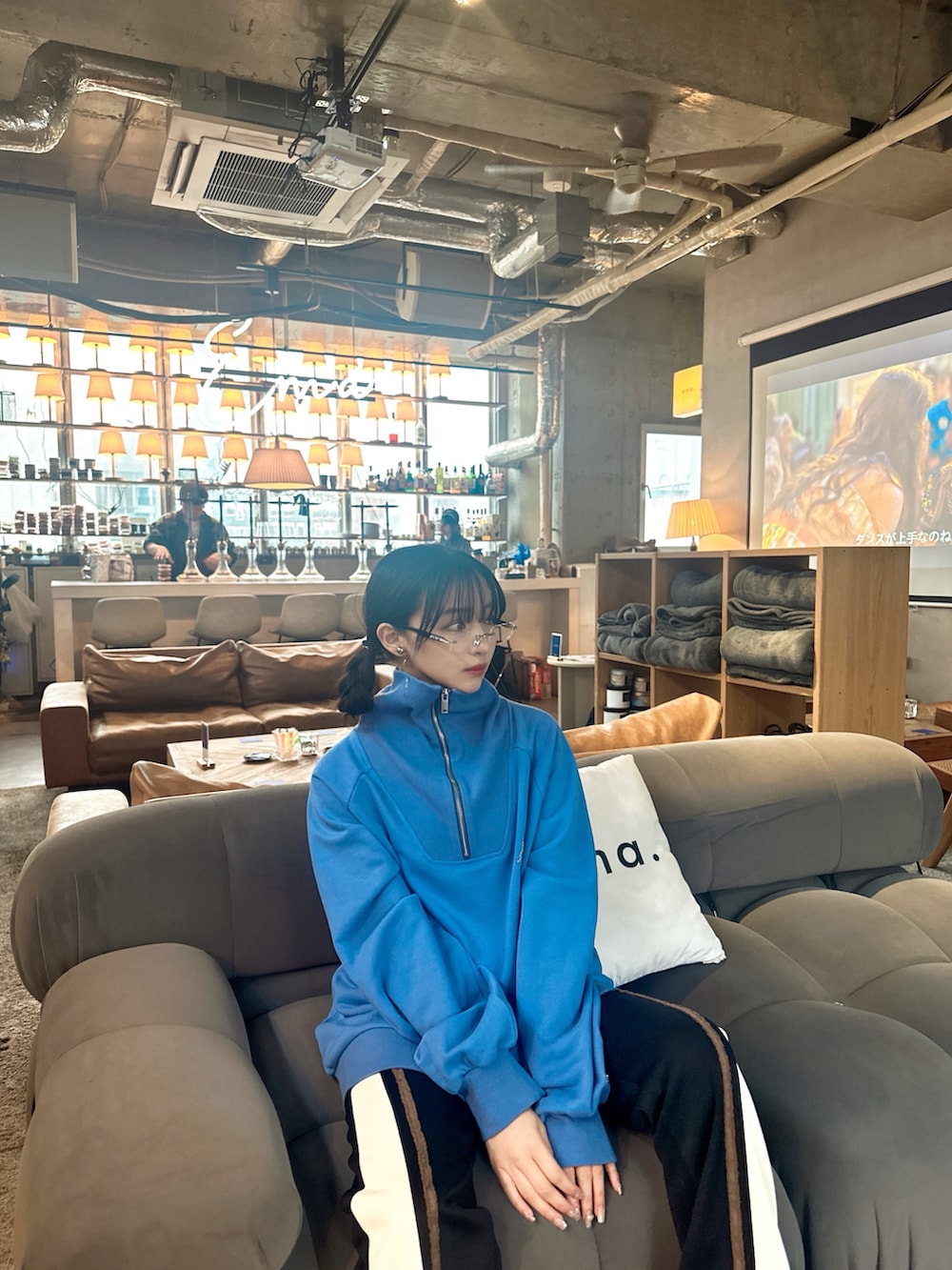 ブルー系のスウェット、ブラック系のパンツを着用したレディースの夏コーディネートの2枚目の写真