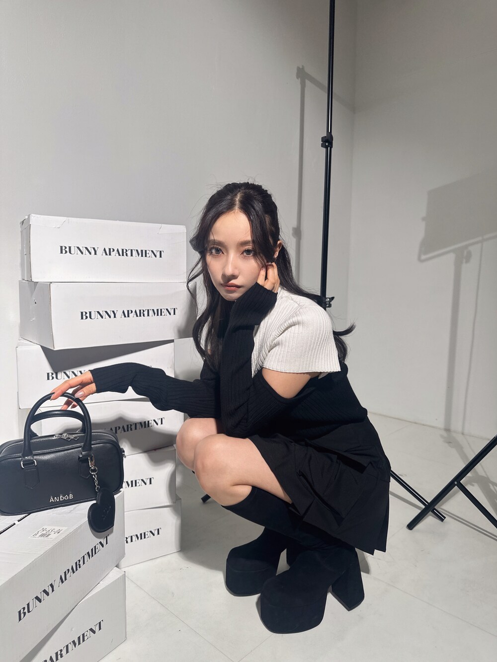 ホワイト系のニット/セーター、ブラック系のスカート、ブラック系のショルダーバッグを着用したレディースの冬コーディネートの2枚目の写真