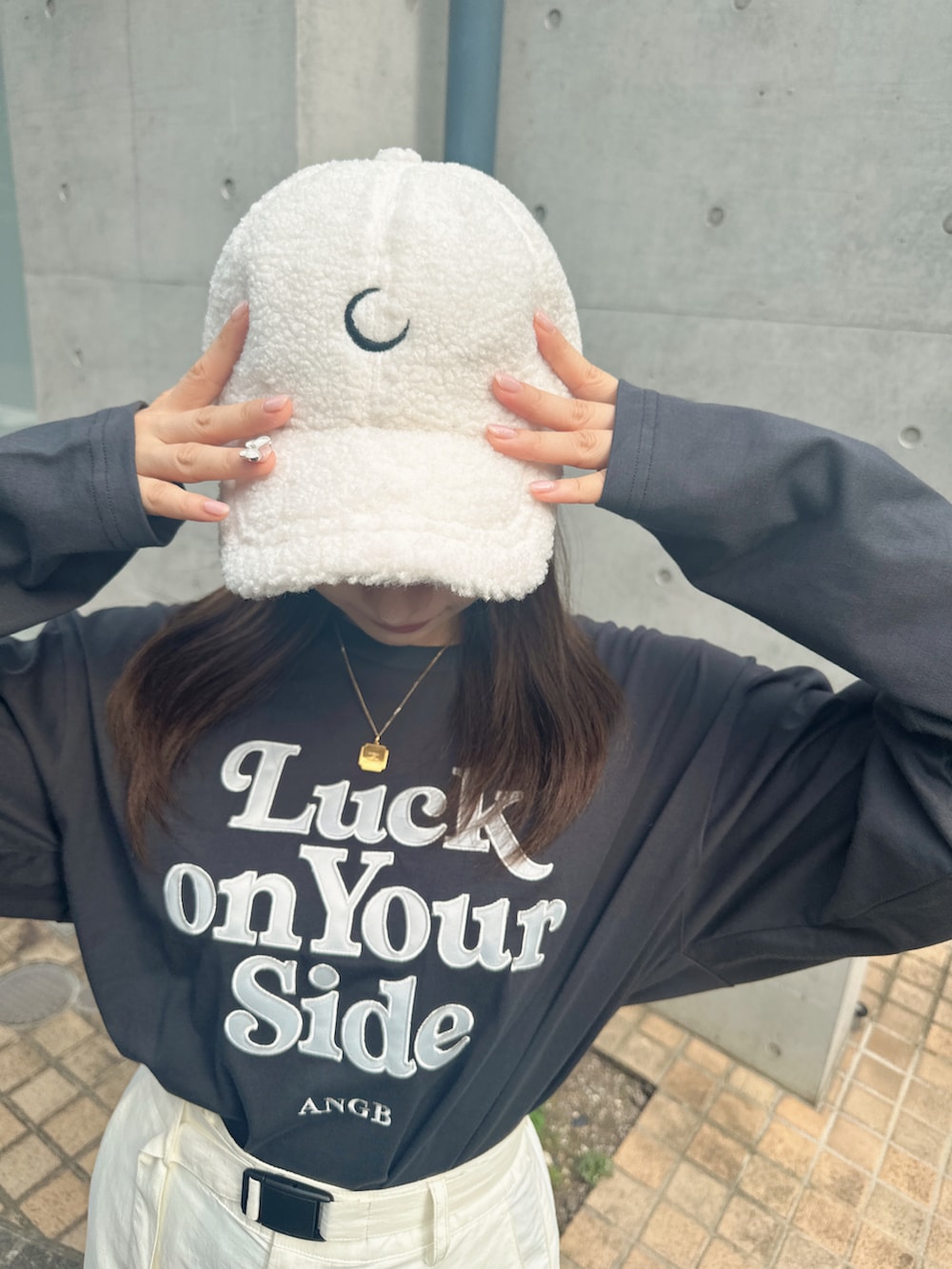 グレー系のTシャツ/カットソー、ホワイト系のキャップを着用したレディースの冬コーディネートの3枚目の写真