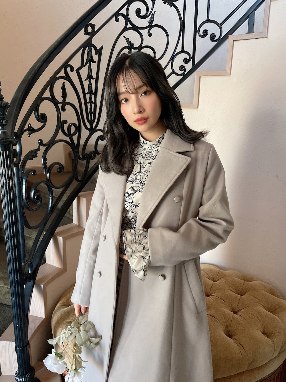 グレー系のチェスターコート、ベージュ系のワンピースを着用したレディースの春コーディネートの3枚目の写真