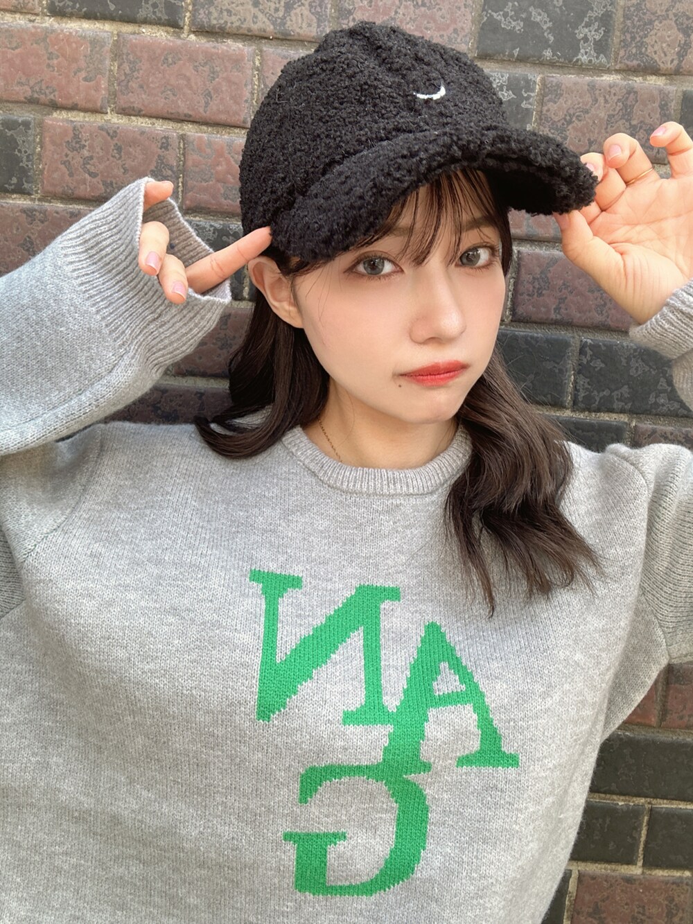 グレー系のニット/セーター、ブラック系のキャップを着用したレディースの秋コーディネートの5枚目の写真