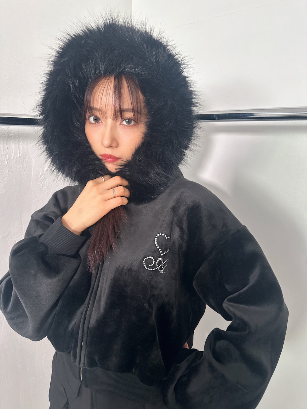 ブラック系のパーカー、ブラック系のスカートを着用したレディースの冬コーディネートの2枚目の写真