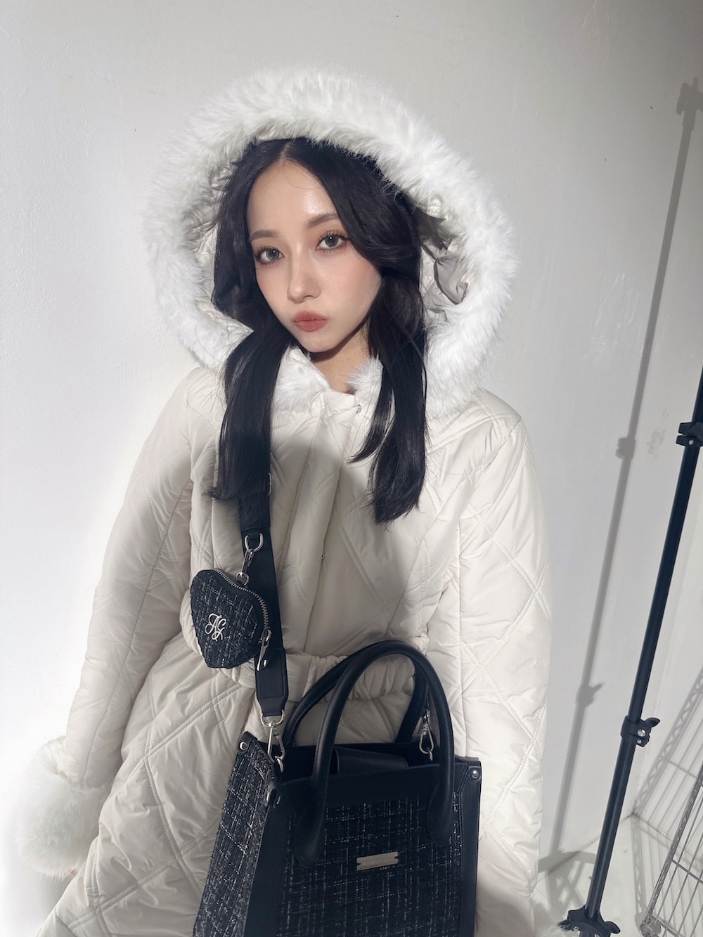 ホワイト系のダウンジャケット/コート、グレー系のショルダーバッグを着用したレディースの冬コーディネートの4枚目の写真