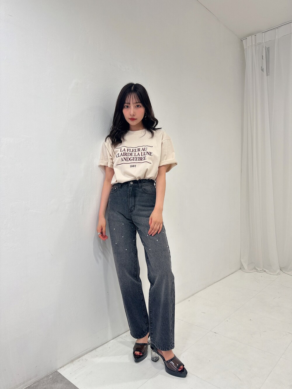 ベージュ系のTシャツ/カットソー、ブラック系のパンツを着用したレディースの秋コーディネートの2枚目の写真