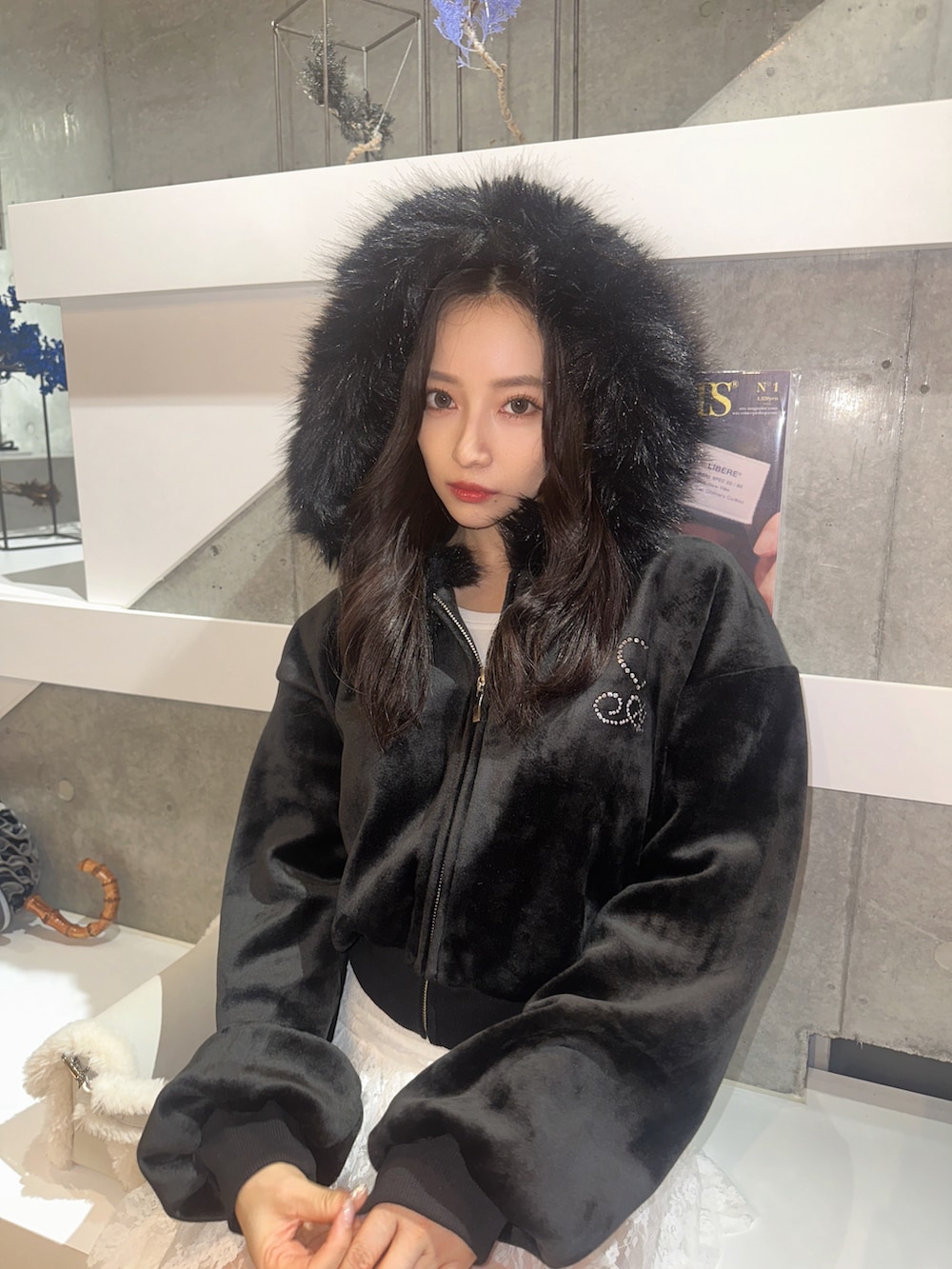 ブラック系のパーカー、ホワイト系のショルダーバッグを着用したレディースの冬コーディネートの5枚目の写真