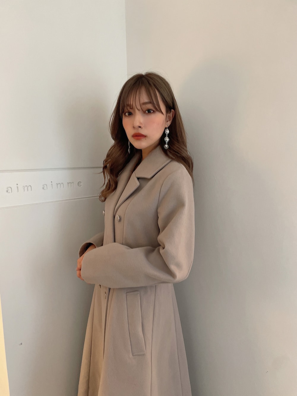 グレー系のチェスターコートを着用したレディースの春コーディネートの2枚目の写真