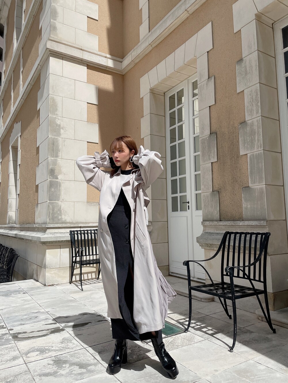 グレー系のトレンチコート、ブラック系のブーツを着用したレディースの秋コーディネートの5枚目の写真