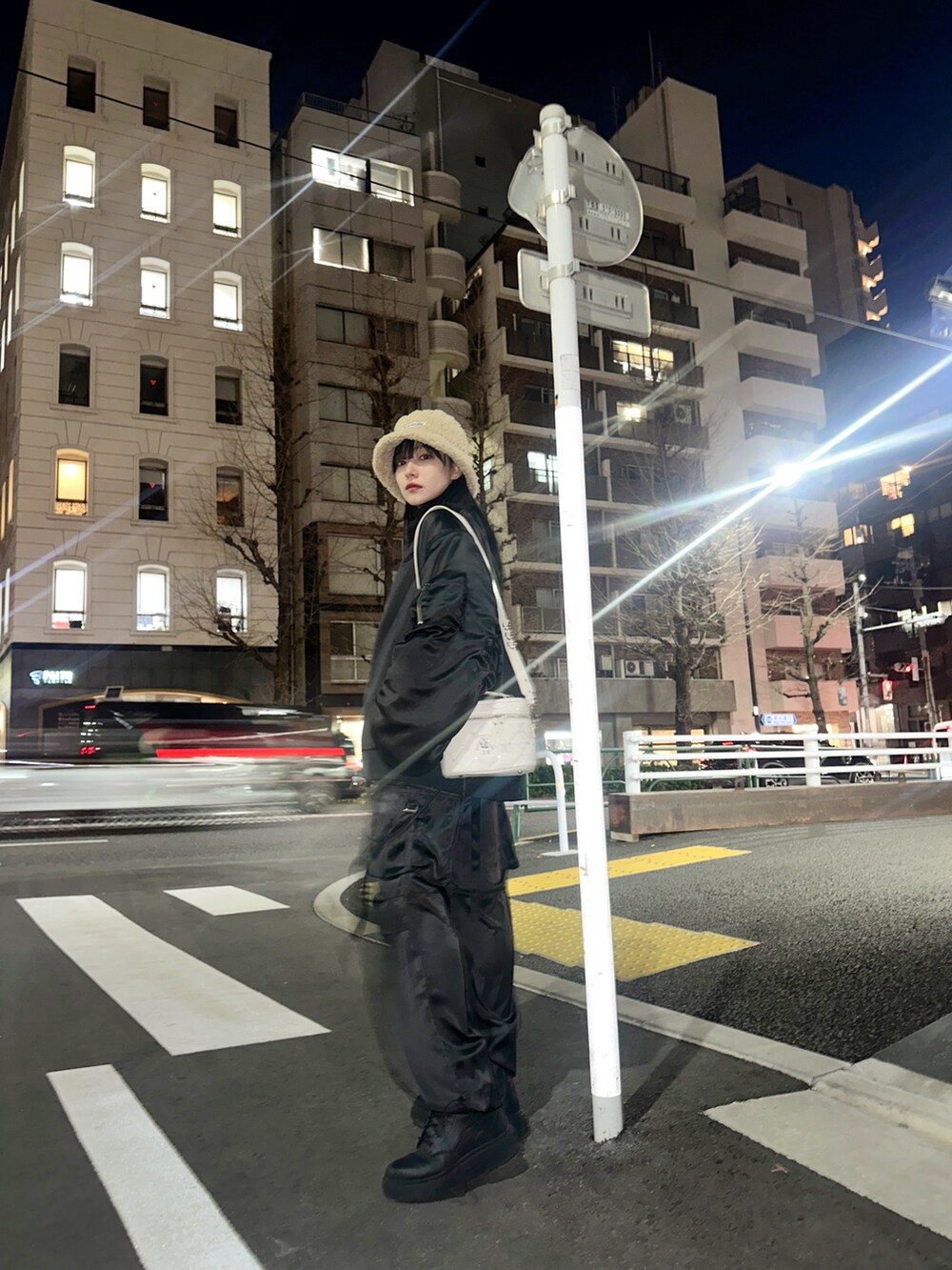 ブラック系のブルゾン、ホワイト系のショルダーバッグ、ブルー系のニット/セーターを着用したレディースの春コーディネートの4枚目の写真