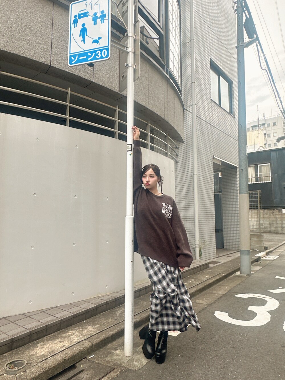 グレー系のニット/セーター、ブルー系のスカートを着用したレディースの秋コーディネートの2枚目の写真