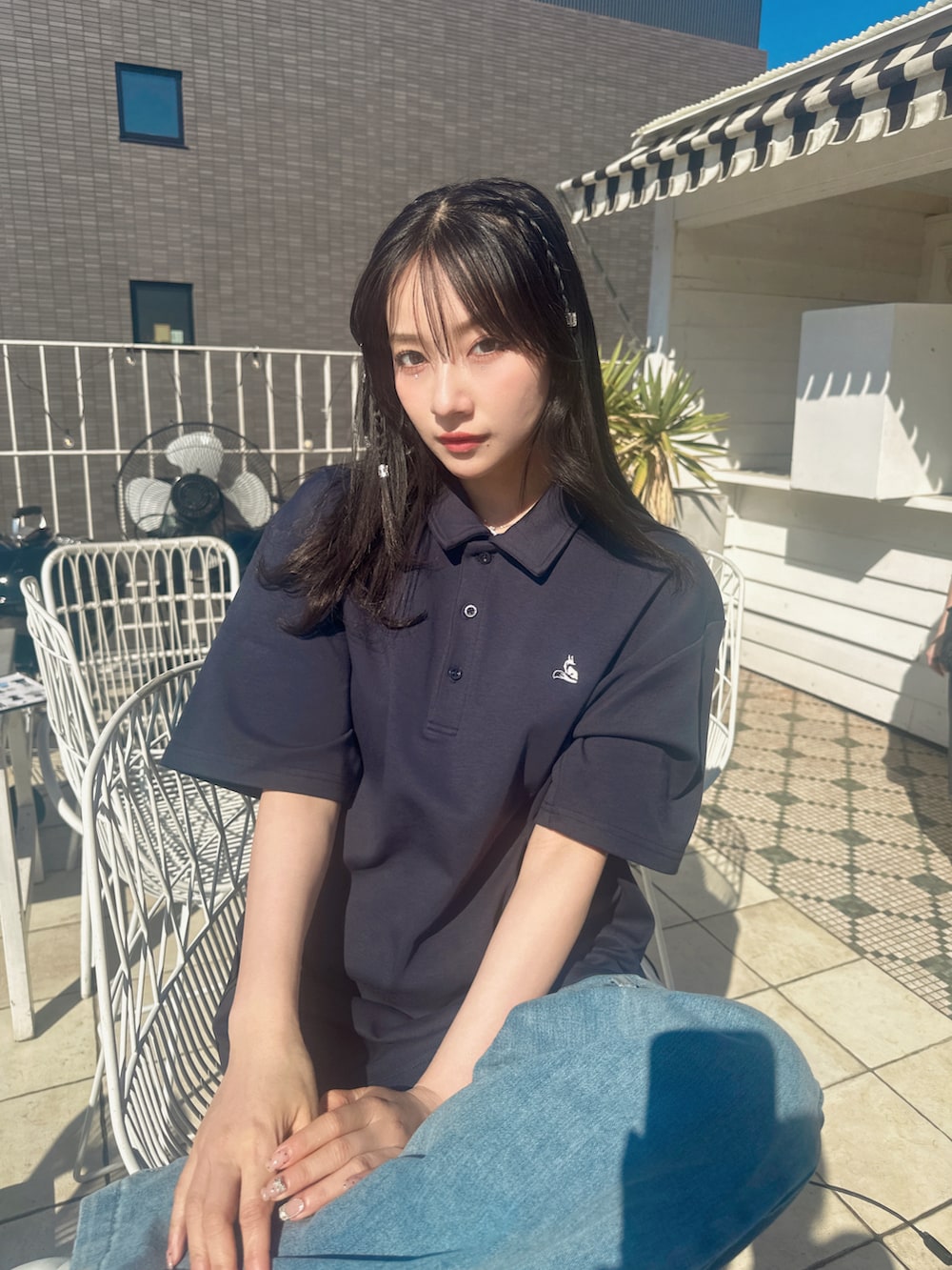 ブルー系のポロシャツを着用したレディースの春コーディネートの2枚目の写真