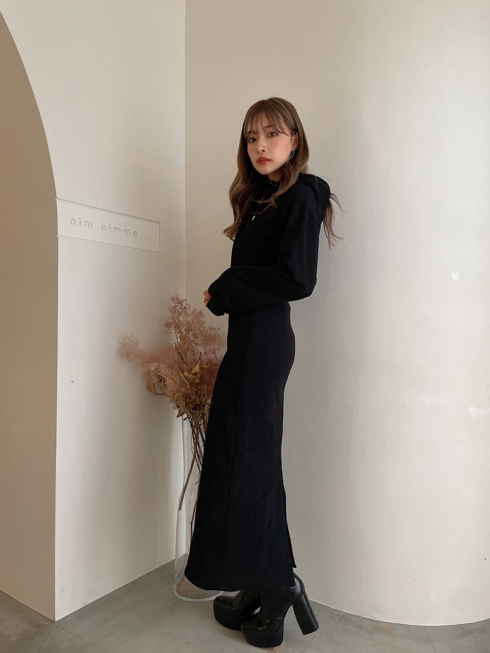 ブラック系のブーツ、ブラック系のワンピースを着用したレディースの秋コーディネートの2枚目の写真