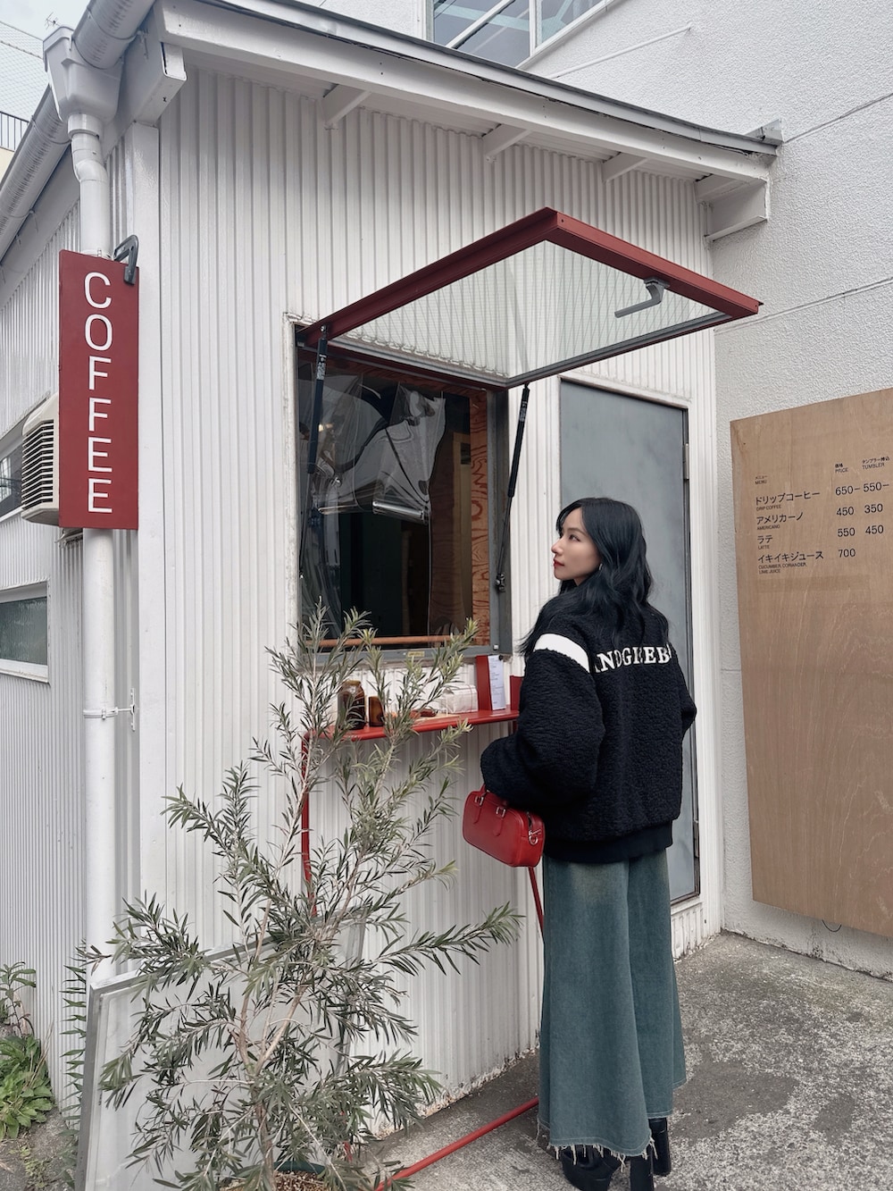 ブラック系のスタジャン、レッド系のショルダーバッグを着用したレディースの春コーディネートの5枚目の写真