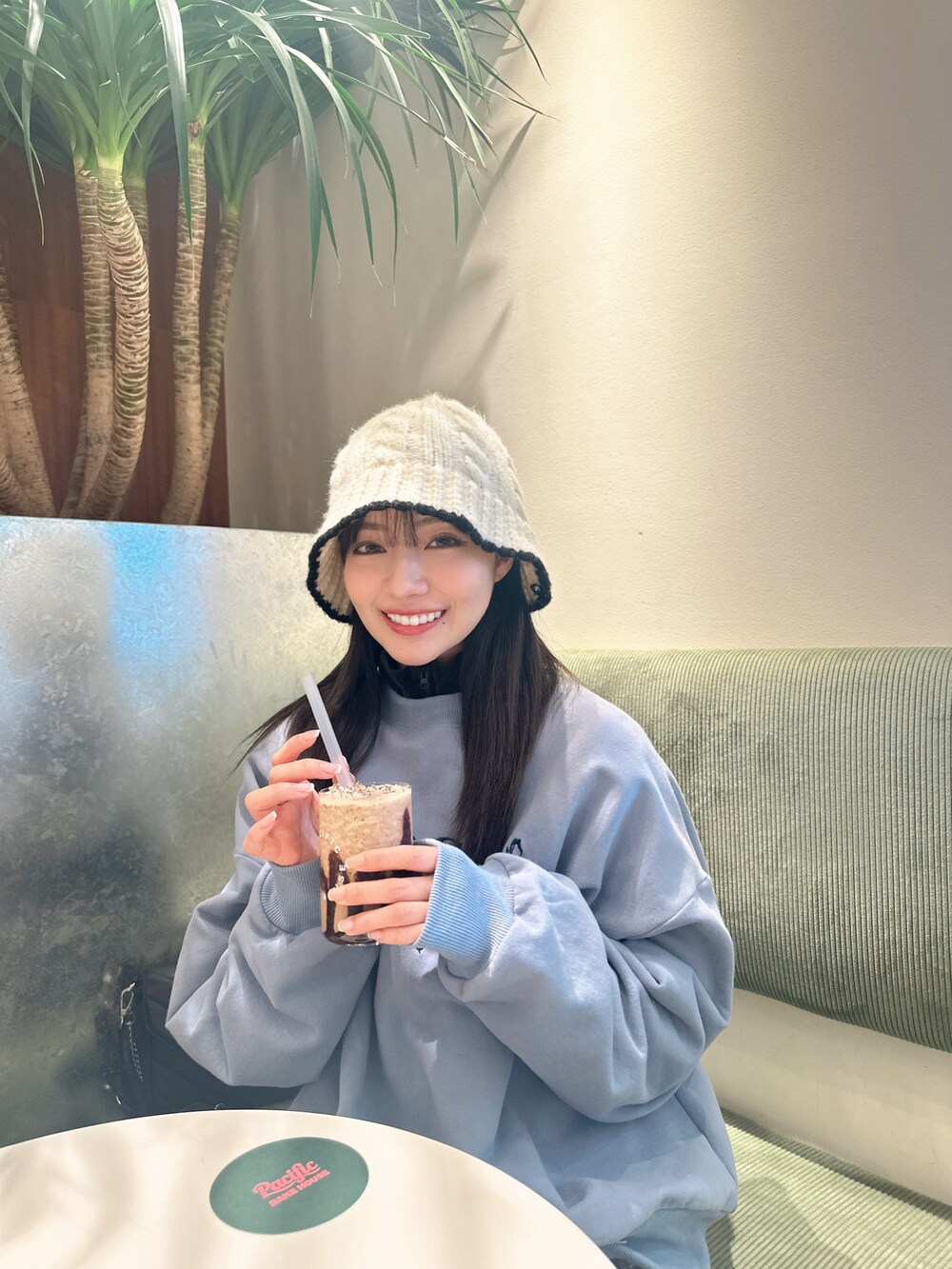 グレー系のスウェット、ホワイト系のハットを着用したレディースの春コーディネートの2枚目の写真