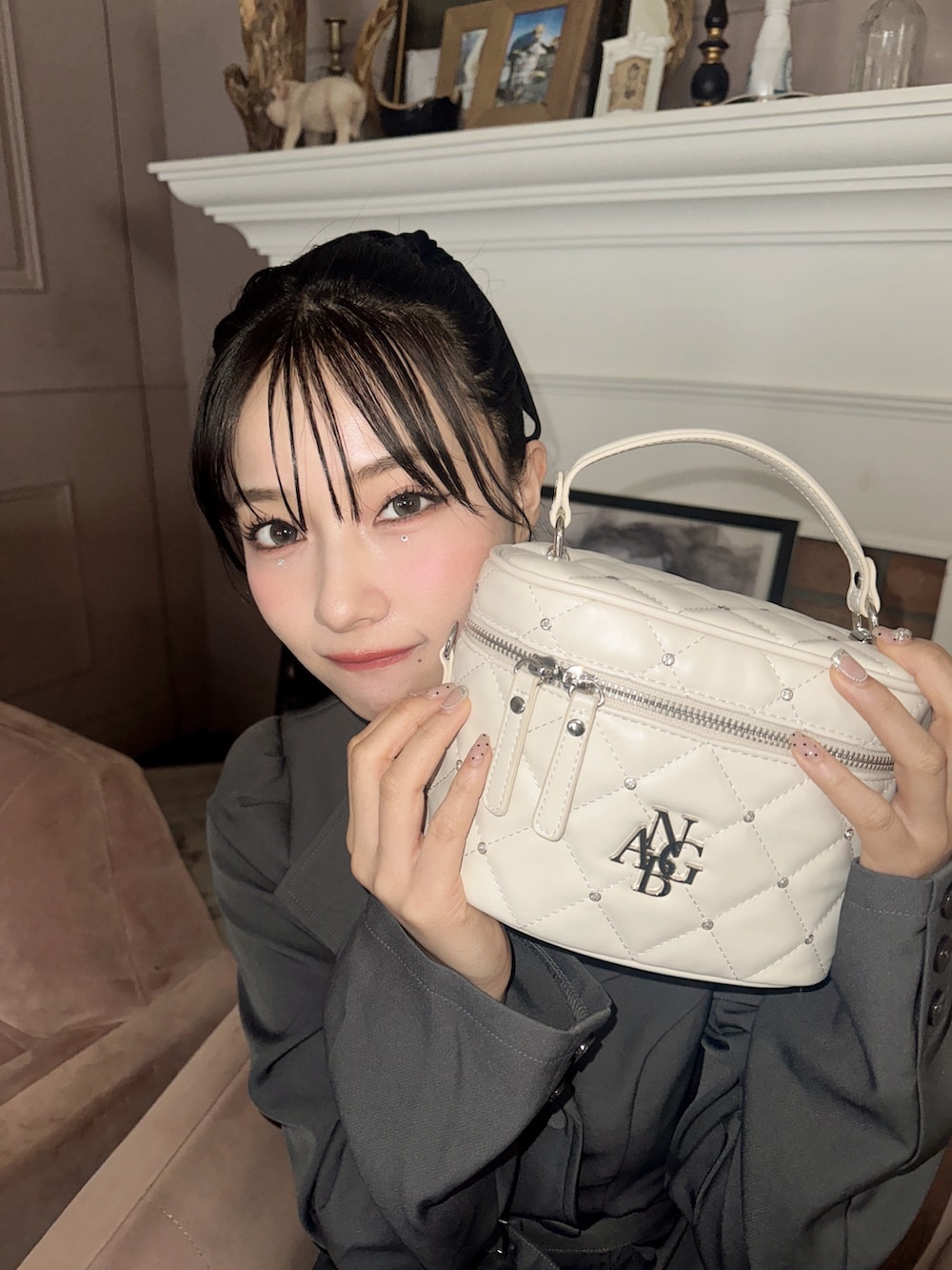 グレー系のワンピース、ホワイト系のショルダーバッグを着用したレディースの春コーディネートの3枚目の写真