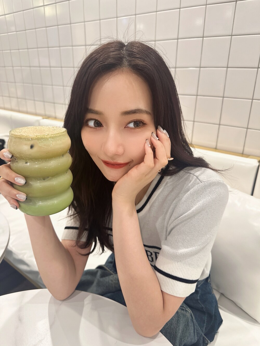 ブルー系のニット/セーターを着用したレディースの夏コーディネートの2枚目の写真