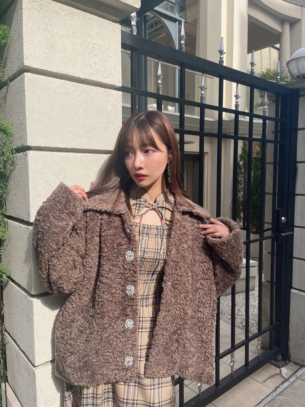 ブラウン系のダウンジャケット/コート、ベージュ系のワンピースを着用したレディースの冬コーディネートの4枚目の写真