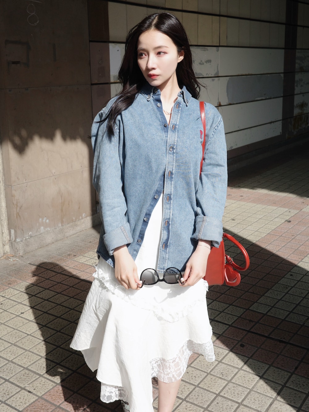 ホワイト系のワンピース、レッド系のショルダーバッグ、ブルー系のトップスを着用したレディースの夏コーディネートの3枚目の写真