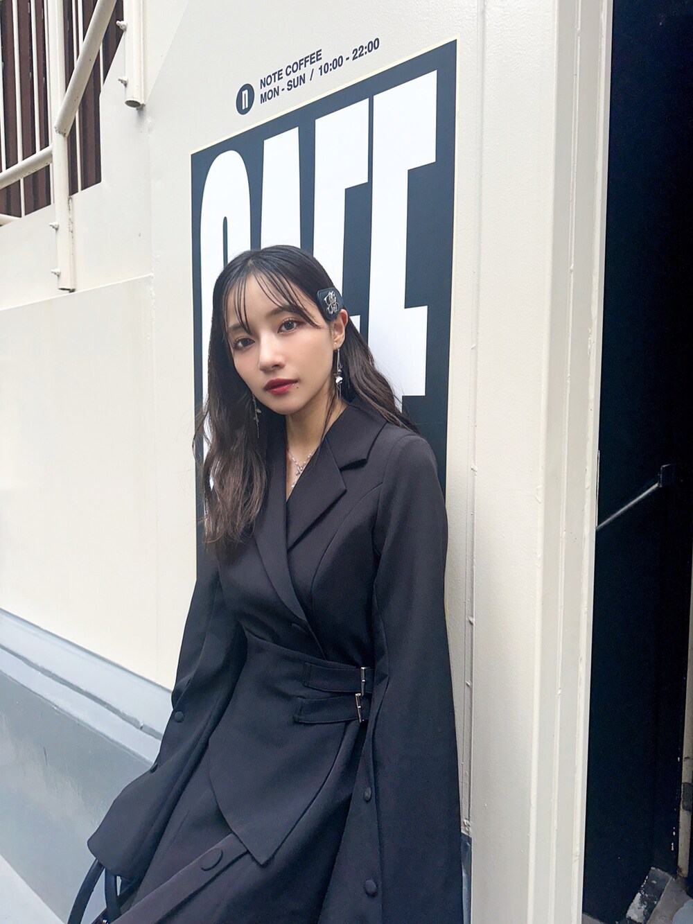 ブラック系のワンピース、ブラック系のショルダーバッグを着用したレディースの冬コーディネートの3枚目の写真