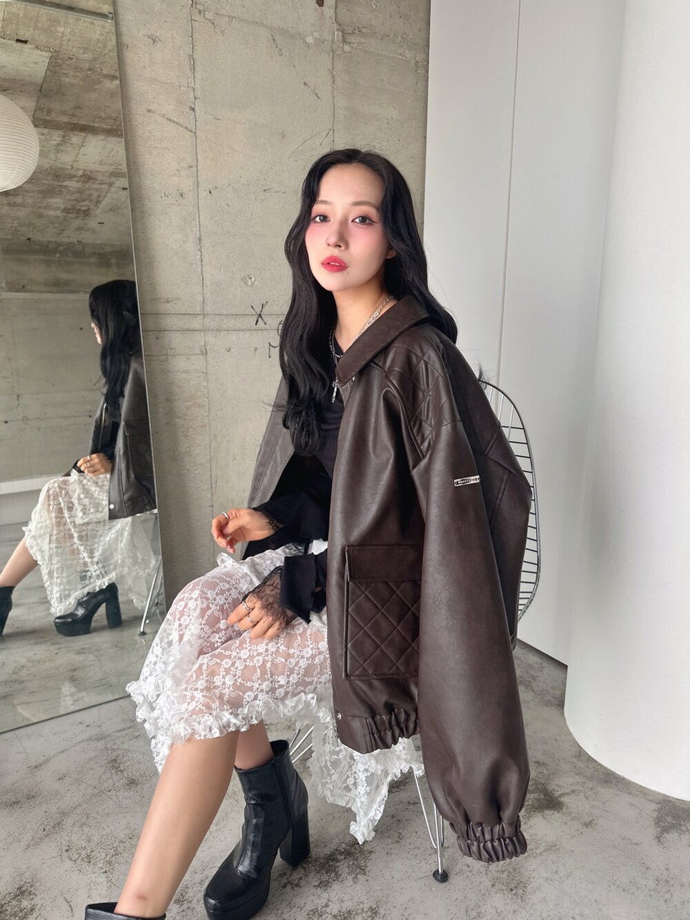 ブラウン系のブルゾン、ブラック系のTシャツ/カットソー、ホワイト系のスカートを着用したレディースの春コーディネートの2枚目の写真