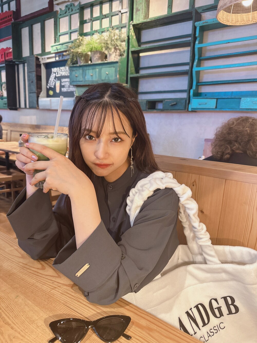 グレー系のシャツ/ブラウス、ホワイト系のトートバッグを着用したレディースの秋コーディネートの4枚目の写真