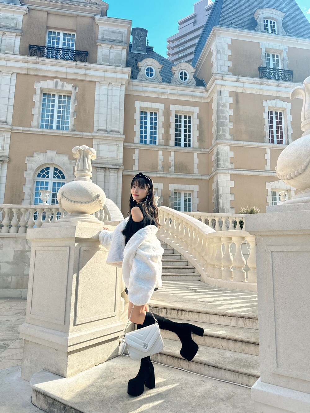 ブラック系のニット/セーター、ホワイト系のその他アウターを着用したレディースの春コーディネートの4枚目の写真